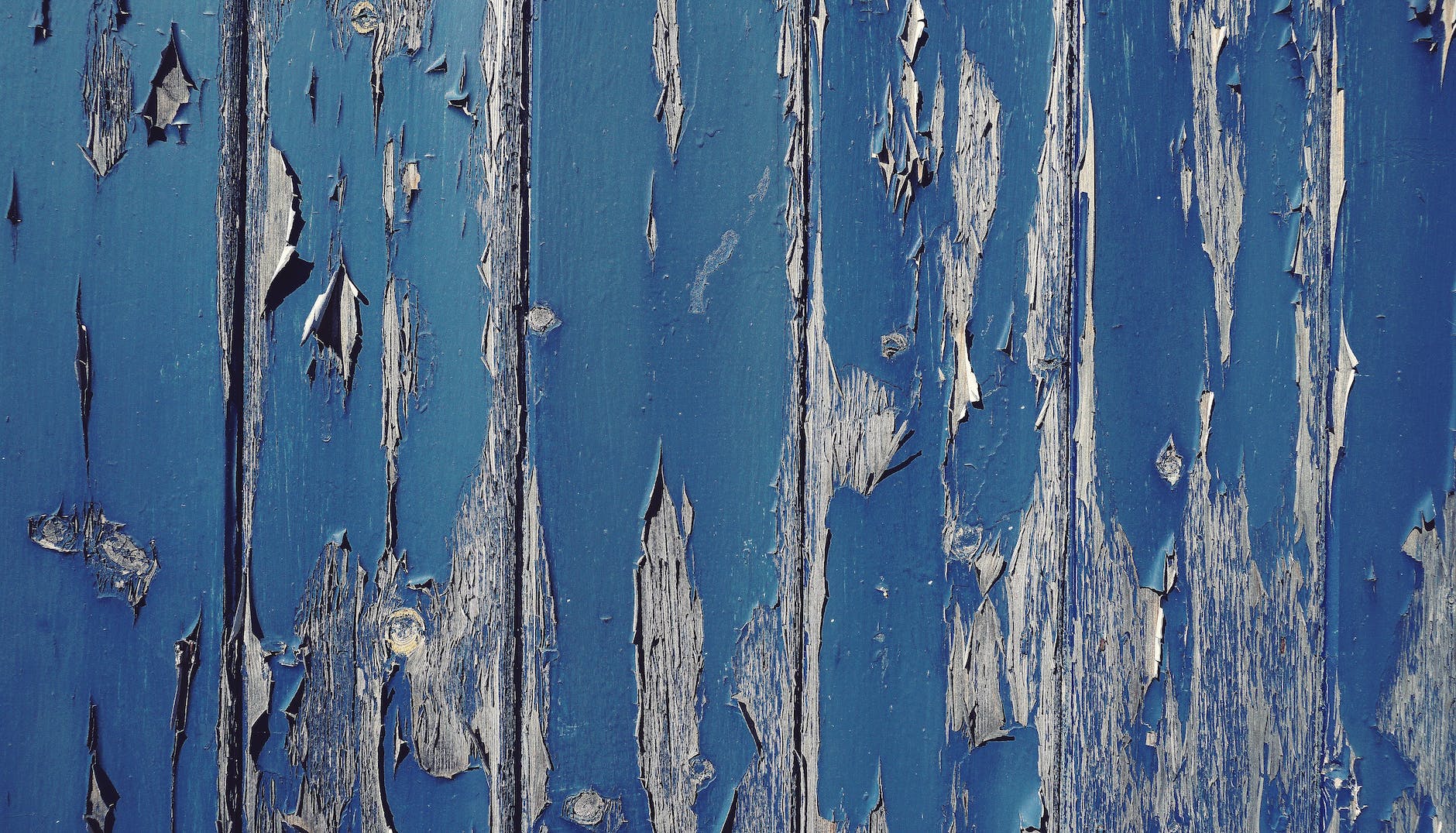 gray wall with cracked blue paint