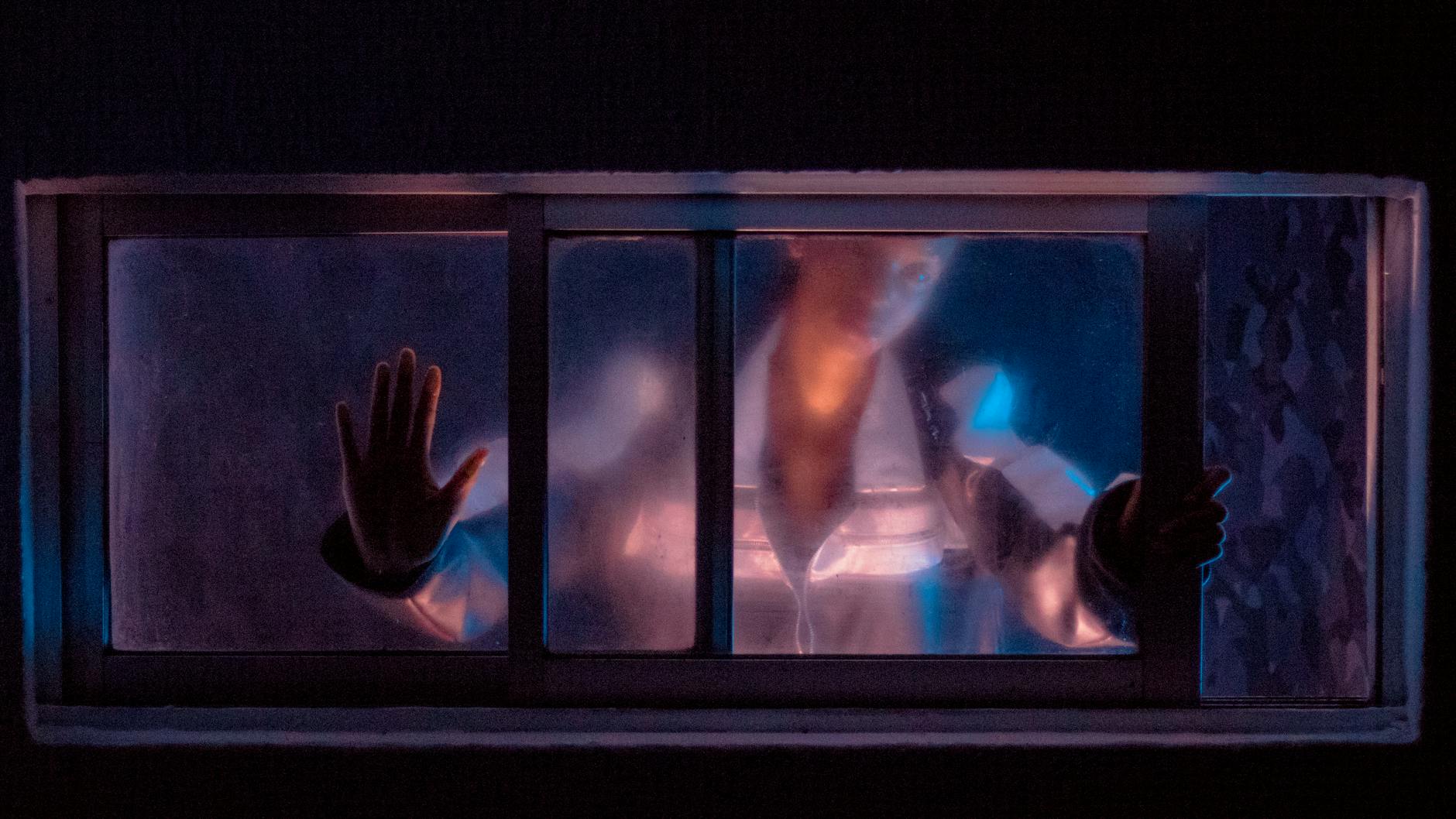 woman standing behind sliding glass window